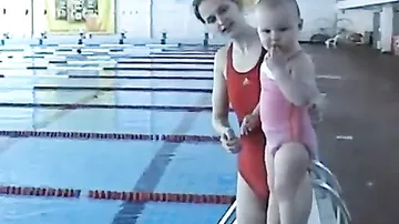 Малыш учится плавать