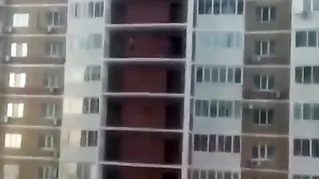 Девушка перелезает через два балкона