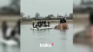 Buz qırıldı: Fəhlələr çayın ortasında avtobusun damında kömək gözlədi