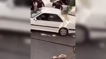В Тегеране полицейские железными дубинками повреждают автомобили