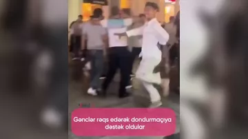 Bir qrup gənc dondurma satıcısına dəstək olmaq üçün onun qarşısında rəqs edib