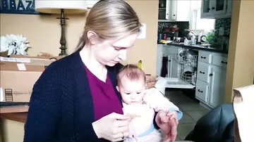 Малышка смеется, когда ее мама ест чипсы