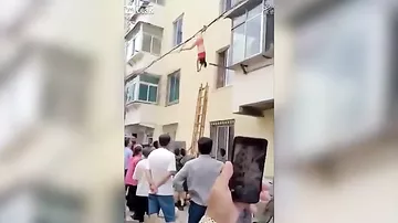 Выпавшая из окна полуголая китаянка чудом выжила, повиснув на проводах
